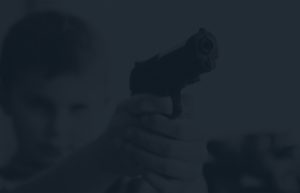Dark view of a child pointing a gun